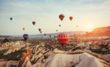 Renkli sıcak hava balonları Cappadocia, Anadolu, Türkiye, kırmızı Vadisi üzerinde uçan. Göreme Milli Parkı içinde volkanik dağlar.