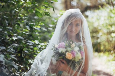 Mutlu bir gelin peçe ile poz portresi.