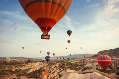 Renkli sıcak hava balonları Cappadocia, Anadolu, Türkiye, kırmızı Vadisi üzerinde uçan. Göreme Milli Parkı içinde volkanik dağlar.