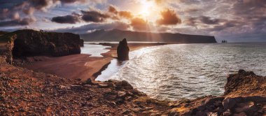 Siyah kum plaj ve dağ Reynisfjara Reynisfyal Cape üzerinden günbatımı İzlanda '.