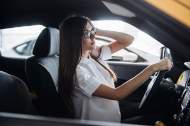 Arabanın ön koltuğunda kameraya bakarak çekici genç beyaz bir kadın