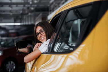 Yeni araba gülümsediğini içinde genç bir kadın.