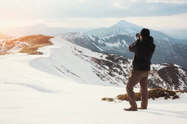 turist manzaraya görünüyor. Fotoğrafçı dağın zirvesinde. Bahar manzara. Karpatlar Ukrayna Europe