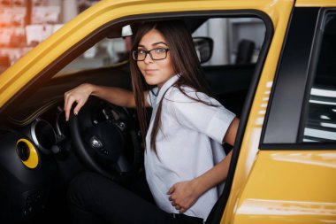 Arabanın ön koltuğunda kameraya bakarak çekici genç beyaz bir kadın