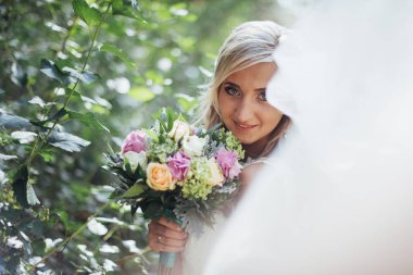 Mutlu bir gelin peçe ile poz portresi.