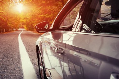 Dağlarda fantastik asfalt yol. Klasik araba. Muhteşem gün batımı.