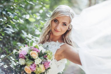 Mutlu bir gelin peçe ile poz portresi.