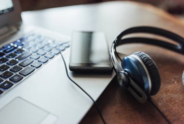 Laptop ve kulaklık ve telefon tablo