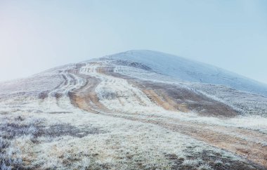 Ekim sıradağlarının ilk kış günlerinde. Sabah güneşi sırasında hoarfrost giden yol. Karpat, Ukrayna, Europe.