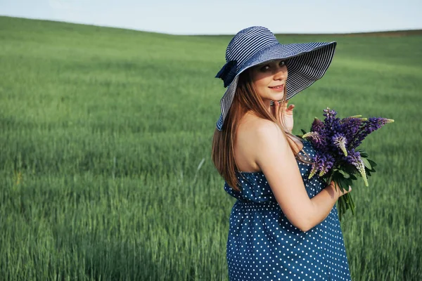 屋外の野生の花の花束とロマンチックな笑みを浮かべて若い女性の肖像画 — ストック写真