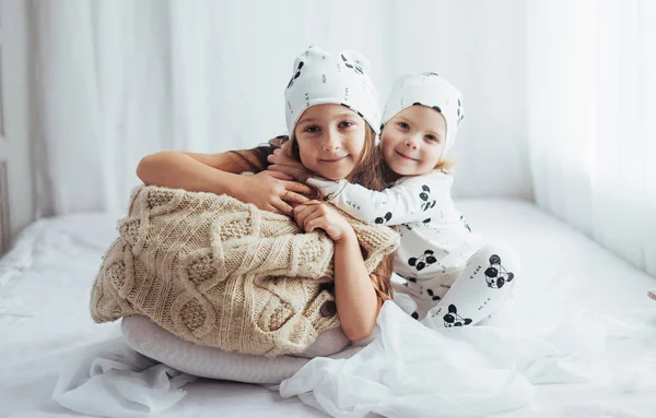 ベッドで遊ぶソフト暖かいパジャマの子供たち — ストック写真