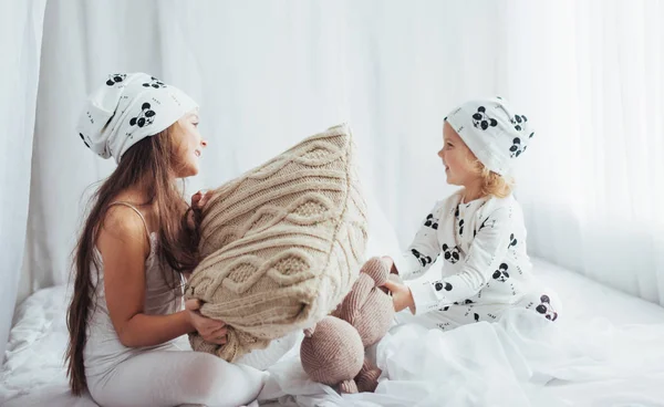 ベッドで遊ぶソフト暖かいパジャマの子供たち — ストック写真