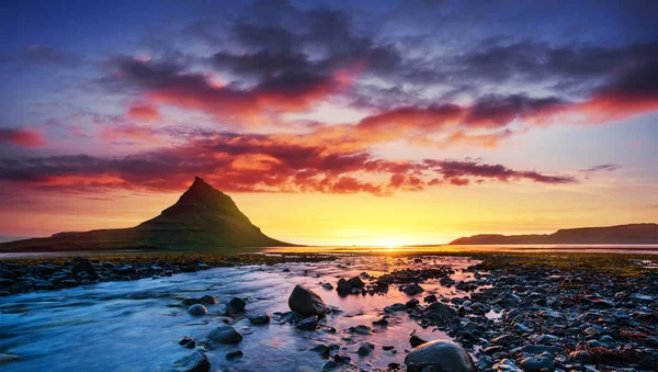 Manzaralar ve şelaleler üzerindeki resimli günbatımı. Kirkjufell Dağı, İzlanda 