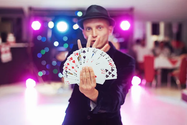 Magician showing trick with playing cards. Magic circus gambling