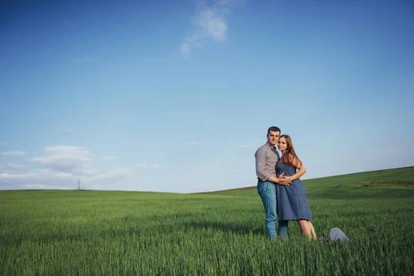幸せな家族が緑の小麦畑で抱き締めます 待っている母子 男性の笑顔 — ストック写真
