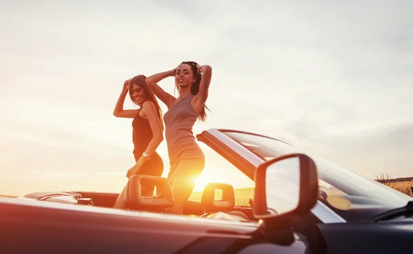 Dos Mujeres Jóvenes Una Sesión Fotos Chicas Posando Alegremente Junto —  Fotos de Stock