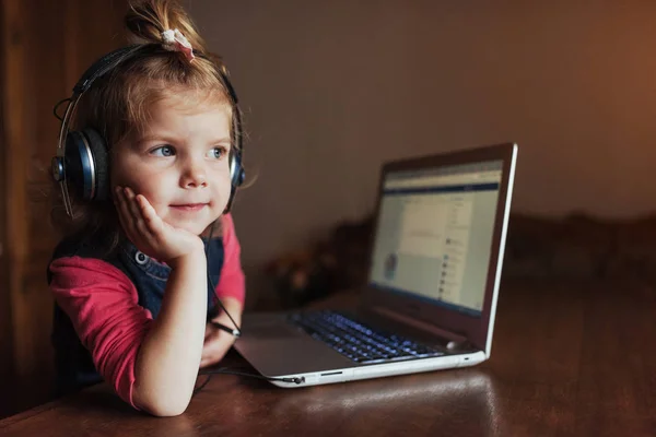 Маленькая Девочка Наушниками Слушает Музыку Используя Ноутбук — стоковое фото