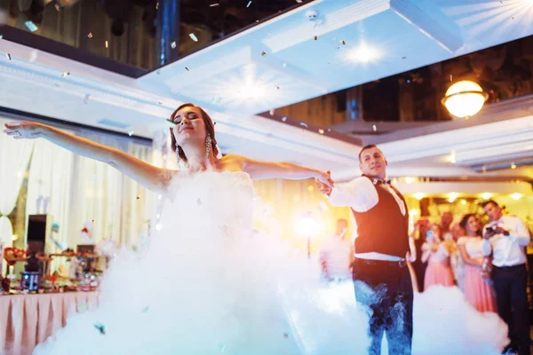 Mutlu gelin ve damat ve ilk dansları, zarif restoranda harika bir ışık ve atmosferi olan düğün.