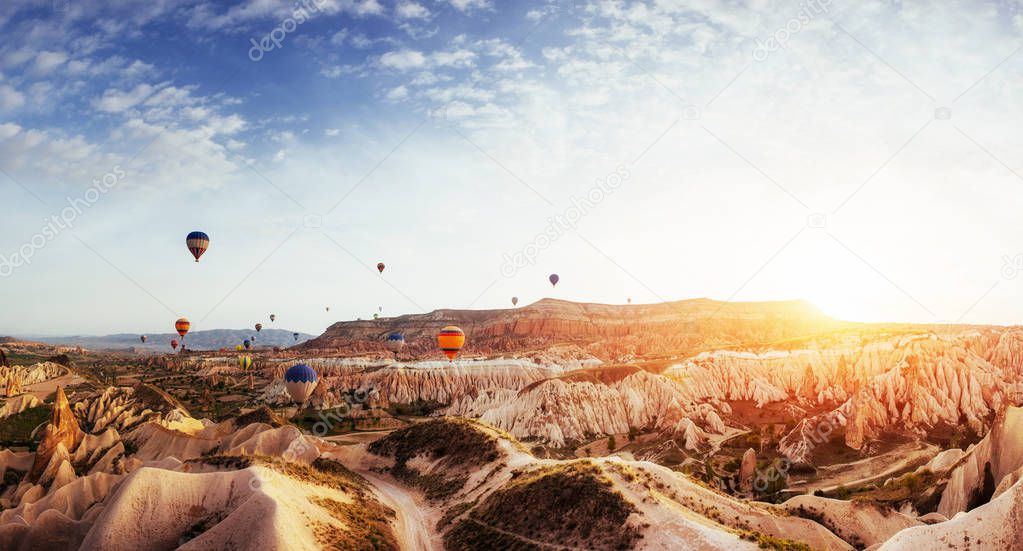 Hot air balloon flying over rock landscape at Turkey. Cappadocia with its valley, ravine, hills, located between the volcanic mountains in Goreme National Park.