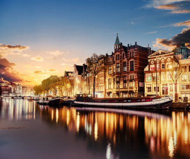 Amsterdam'da güzel bir gece. gece aydınlatma bina ve su kanalına yakın tekneler.
