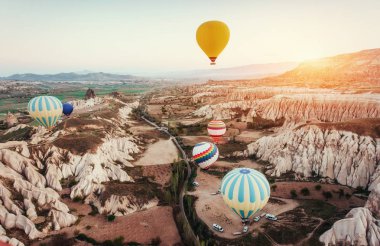 Renkli sıcak hava balonları Cappadocia, Anadolu, Türkiye, kırmızı Vadisi üzerinde uçan. Göreme Milli Parkı içinde volkanik dağlar.