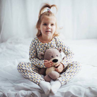 Yumuşak sıcak pijama yatakta oynayan çocuk