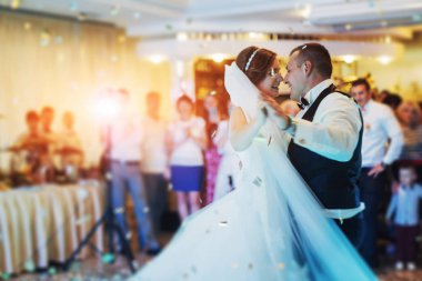 Mutlu gelin ve damat ve ilk dansları, zarif restoranda harika bir ışık ve atmosferi olan düğün.