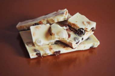 beyaz çikolatalı Fındıklı, kahverengi bir arka plan üzerine kuru üzüm.