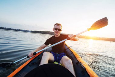 fantastik günbatımı bir kayık içinde gölde yüzen adam