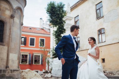 Mutlu bir çift düğün portre. Stand ve eski şehrin sokaklarında öpüşme.