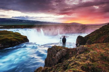 Güzel İzlanda şelale Hodafoss. Kuzey Lake Myvatn ve çevre yolunun yakınında yer almaktadır. Harika manzara. Güzel cumulus bulutları. Adam güzellik dikkate alır.