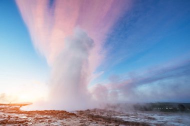 Strokkur şofben Erüpsiyonu İzlanda '. Harika renkler steam üzerinden Parlatıcı. Mavi gökyüzünde güzel pembe bulutlar.