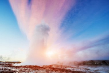 Strokkur şofben Erüpsiyonu İzlanda '. Harika renkler steam üzerinden Parlatıcı. Mavi gökyüzünde güzel pembe bulutlar.