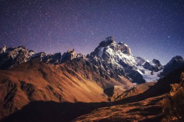 Fantastik yıldızlı gökyüzü. Sonbahar manzara ve karla kaplı tepeler. Ana Kafkas Ridge. Mountain View Dağı dır Meyer, Gürcistan'dan. Europe