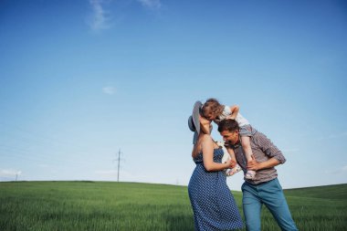 Mutlu aile üç insan sokaklarda sarılma. Anne bekleyen çocuk. Kadın, erkek ve çocuk gülümseyen yüzler. Çocuklar ebeveynleri ile oynamak