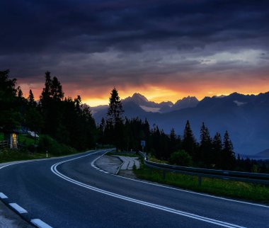 Dağlara giden fantastik günbatımı. Asfalt yol ile beyaz markings. Güzel yaz manzara. Yumuşak filtre uygulanmış etkisi. Europe