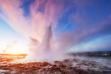 Strokkur şofben Erüpsiyonu İzlanda '. Harika renkler steam üzerinden Parlatıcı. Mavi gökyüzünde güzel pembe bulutlar.