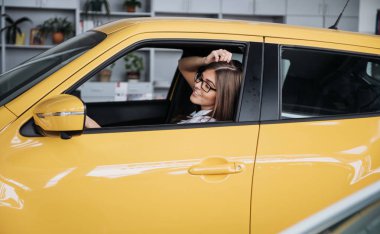 Arabanın ön koltuğunda kameraya bakarak çekici genç beyaz bir kadın