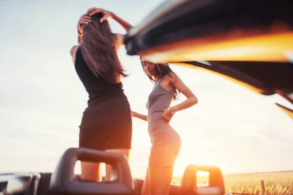 Girls Gladly Posing Next Black Car Sky Fantastic Sunset — Stock Photo, Image