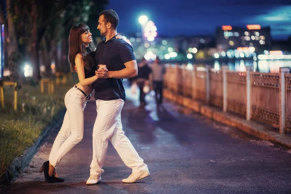 年轻夫妇跳舞探戈在河的河堤在晚上 — 图库照片