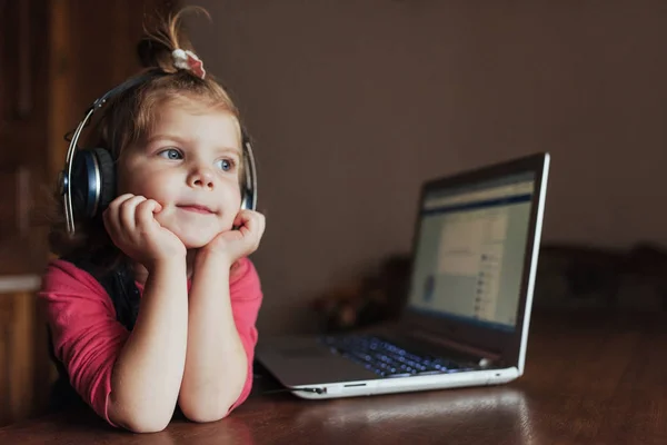 Маленькая Девочка Наушниками Слушает Музыку Используя Ноутбук — стоковое фото