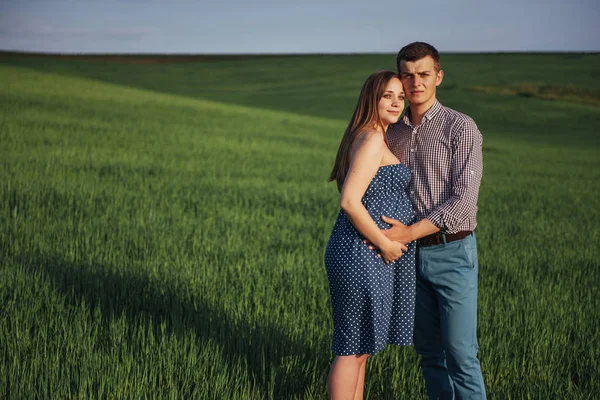 幸せな家族が緑の小麦畑で抱き締めます 待っている母子 男性の笑顔 — ストック写真
