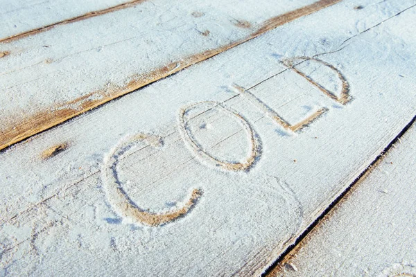 Writing on the snow. Wooden texture. Symbols on wooden board.