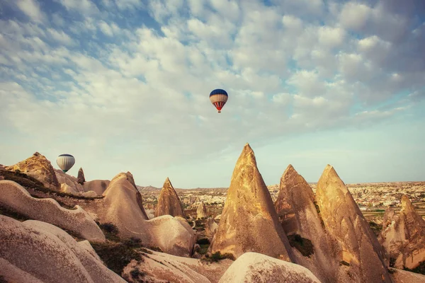 Hot air balloon flying over rock landscape at Cappadocia Turkey. Cappadocia with its valley, ravine, hills, located between the volcanic mountains in Goreme National Park.