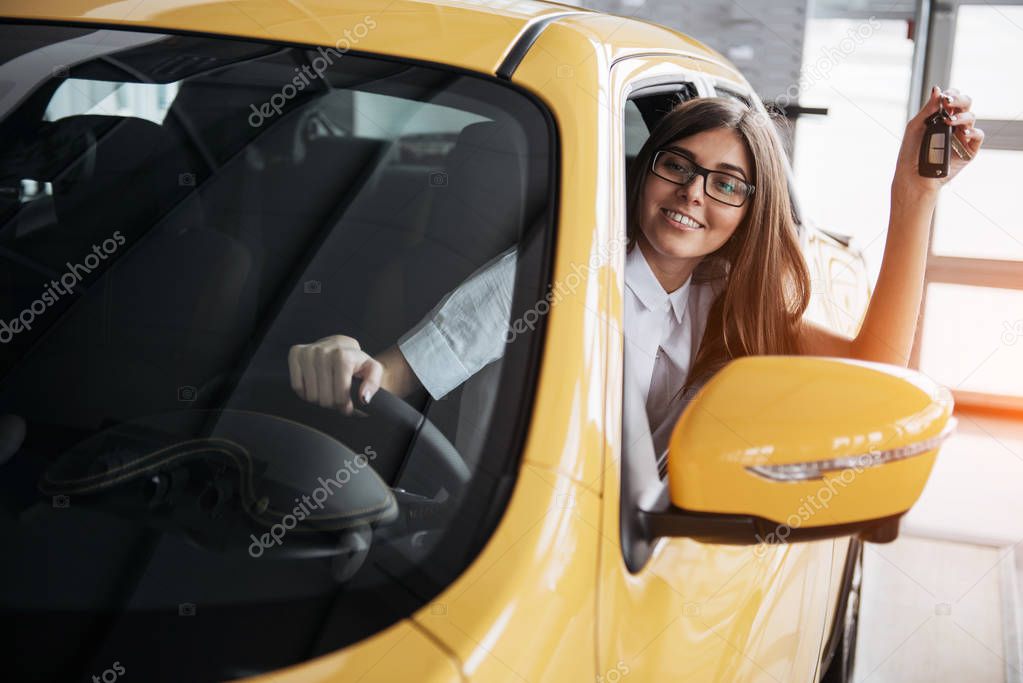 The woman driver smiling showing new car keys.