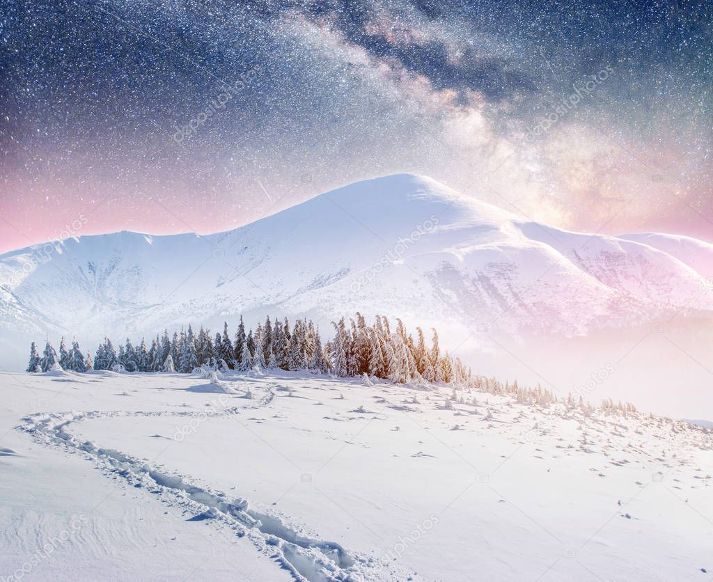 starry sky in winter snowy night. fantastic milky way in the New Year's Eve. Starry sky snowy winter night. The Milky Way is a fantastic New Year's Eve. Winter road in the mountains