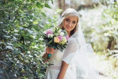 Mutlu bir gelin peçe ile poz portresi.