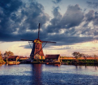 Renkli bahar günü ile geleneksel Hollanda Rotterdam kanalda yel değirmenleri. Ahşap iskele göl kıyısı yakınında. Holland. Hollanda.