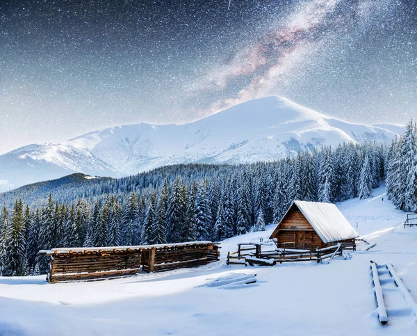 chalets in the mountains at night under the stars. Magic event in frosty day. In anticipation of the holiday. Dramatic scenes. Carpathians, Ukraine, Europe