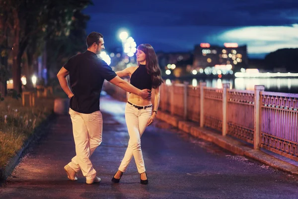 年轻夫妇跳舞探戈在河的河堤在晚上 — 图库照片